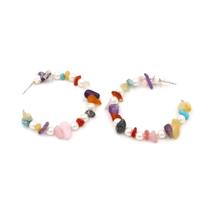 Detail of C-shaped hoop earrings featuring colorful crushed stones and white pearls