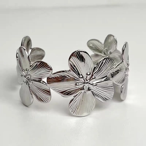 Detailed macro view of 18K gold floral cuff bracelet with intricate petal texture