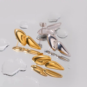 Detail of irregular liquid metal drop earrings in polished gold and silver finish