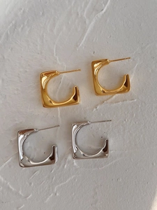 Detailed view of geometric square C-shaped earrings in polished gold and silver finishes