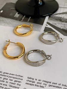 Detailaufnahme goldener und silberner dicker Creolen mit S925-Punze auf den Steckern