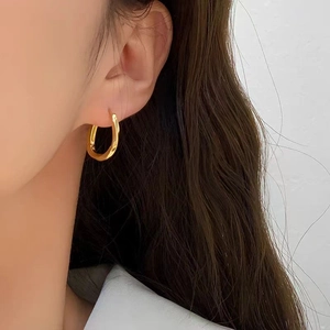 Chic gold geometric twisted hoop earrings with a glossy finish for a modern commute style