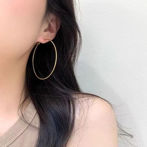 Chic gold-toned large hoop earrings with textured spiral design for elegant women