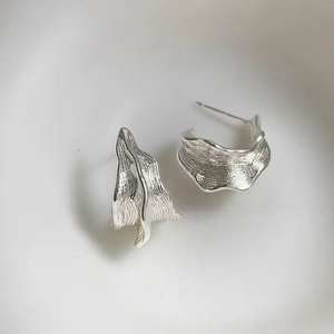 Detailed view of silver irregular wrinkled texture earrings with organic wavy design