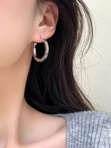 Detail view of silver layered cube hoop earrings with textured geometric surface on model