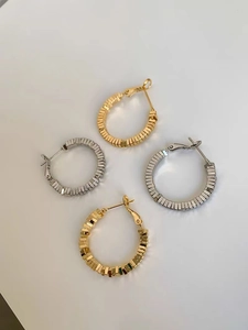 Detail of geometric square layered hoop earrings in gold and silver metallic finishes