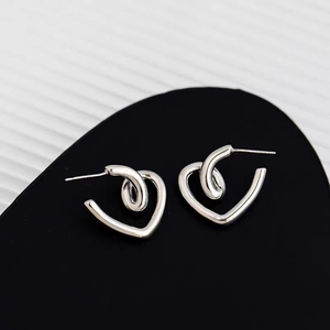 Macro shot of silver heart studs with a unique spiral twist and high polish finish