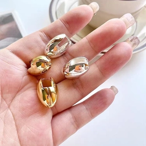 Minimalist egg-shaped oval metal hoop earrings in polished gold and silver finishes