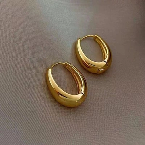 Polished gold chunky oval hoop earrings with a sleek minimalist teardrop design