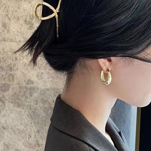 Minimalist gold teardrop hoop earrings and bamboo style hair claw set on elegant model