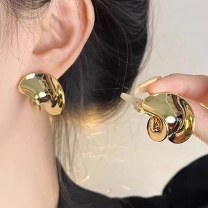 Gold irregular fluid spiral earrings with polished finish for women in minimalist style