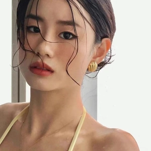 French vintage style gold shell earrings and thin chain necklace on a female model