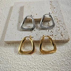 Detailed view of geometric irregular hoop earrings in polished gold and silver finishes