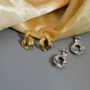 Boucles d'oreilles nœuds géométriques en or et argent avec un design 3D métal irrégulier