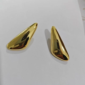 Macro view of polished 18K gold-plated irregular triangle geometric stud earrings