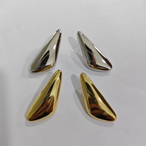Macro view of smooth 18K gold and silver plated geometric drop earrings in polished finish