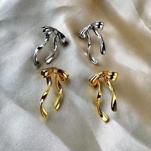 Elegant 18K gold and silver plated butterfly ribbon drop earrings on silk background