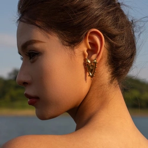 Chic 18K gold plated chunky geometric heart earrings worn by a model in soft sunset light