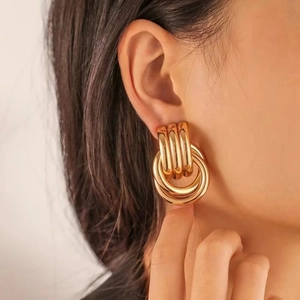 Close-up of chunky multi-layered 18K gold plated hoop earrings worn by a model