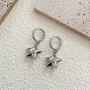 Orecchini a cerchio con stella in argento placcato oro 18K su superficie minimale