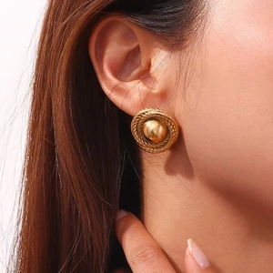 Close-up of 18K gold-plated geometric round stud earrings with vintage braided texture