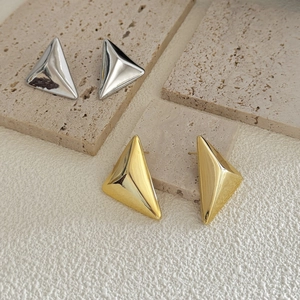 Polished geometric triangle stud earrings in gold and silver finish on stone base