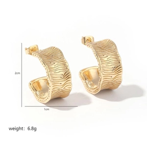 Detail of 18K gold C-shape earrings with irregular wavy texture and 2cm size specs