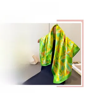 Detail of elegant yellow and green silk scarf with abstract print on a hanger