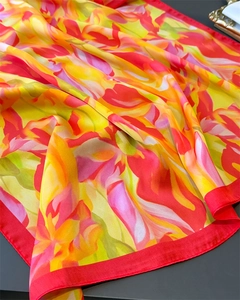 Macro view of colorful floral silk scarf showing soft texture and vibrant print details