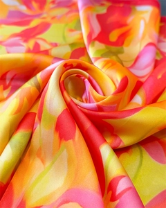 Macro shot of silk scarf with floral patterns showing luxurious smooth satin texture