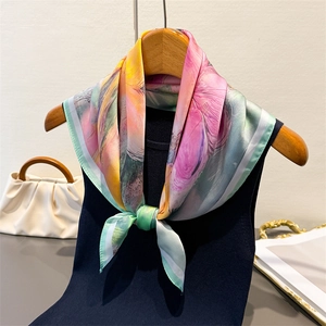Foulard en soie aux imprimés artistiques pastels noué sur un débardeur bleu marine