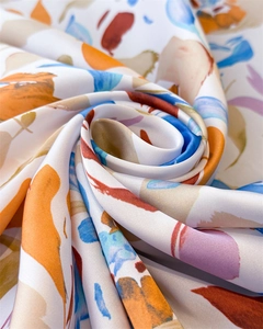 Détail d'un foulard en soie vintage montrant une texture soyeuse et un motif cachemire coloré