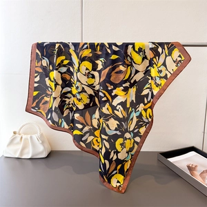 Détail d'un carré de soie vintage aux motifs floraux abstraits jaune et marron élégants