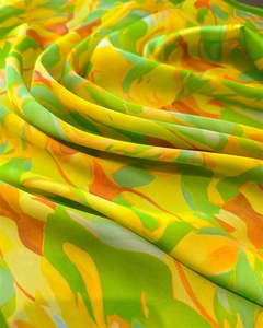 Close-up of luxury silk-like scarf with abstract yellow and green artistic print