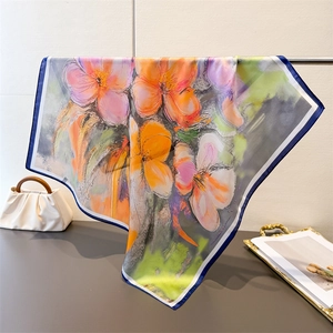 Vue détaillée du foulard en soie avec grand imprimé floral aux pétales orange et rose