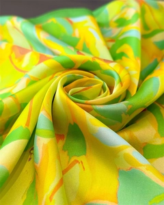 Close-up of vibrant satin silk scarf featuring colorful floral patterns and smooth texture