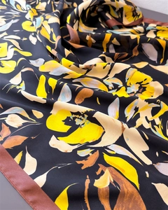 Détail d'un foulard en soie vintage aux motifs floraux, texture drapée et bordure marron