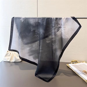 Detailansicht eines transparenten Schals mit Farbverlauf-Druck an einem Displayständer