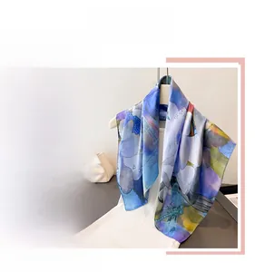 Detail of silk scarf with dragonfly and floral print in blue and yellow tones