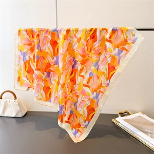 Close-up of elegant floral silk scarf draped on metal bar showing its smooth texture