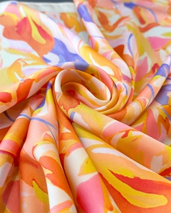 Close-up of abstract floral silk scarf with vibrant orange and purple patterns