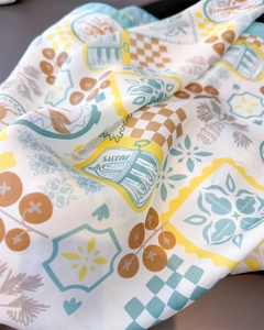 Detail of silk scarf showing sardine illustrations and plaid patterns with smooth texture