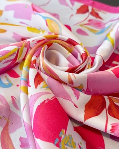 Détail d'un foulard en soie avec imprimé floral abstrait et couture de bordure rose