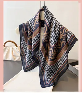 Detail of silk-feel scarf with houndstooth and baroque patterns hanging on a hanger