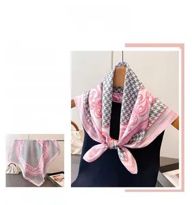 Detail of pink houndstooth silk scarf showing smooth texture and elegant floral border