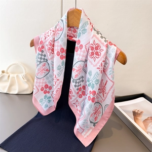 Elegant floral silk scarf with lobster print hanging on a wooden hanger with pearl handbag