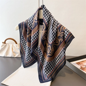 Detail of silk square scarf featuring houndstooth pattern and golden baroque accents