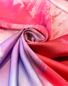 Nahaufnahme eines Seidenschals mit rosa-violettem Farbverlauf und feiner Marmortextur