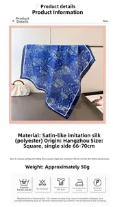 Détail du foulard bleu en satin soyeux avec des motifs paisley blancs élégants
