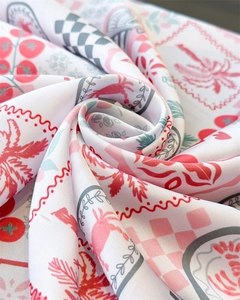 Detail of twisted silk scarf showing red palm trees and pink checkered patterns